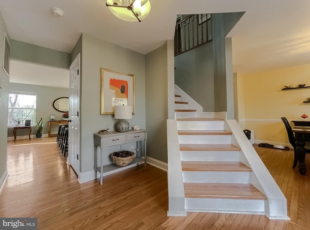 stairs featuring wood finished floors and baseboards