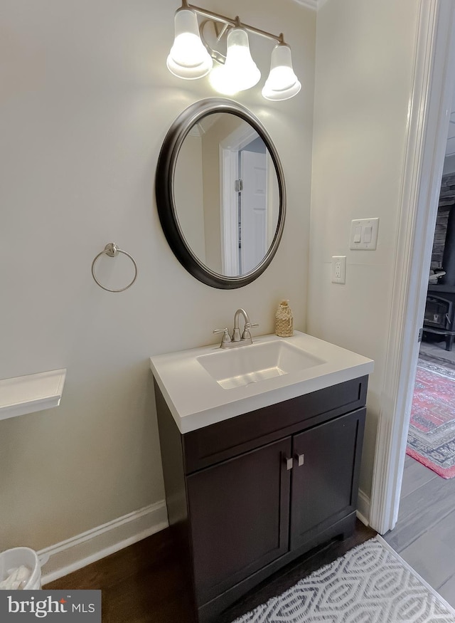 bathroom featuring vanity, baseboards, and wood finished floors