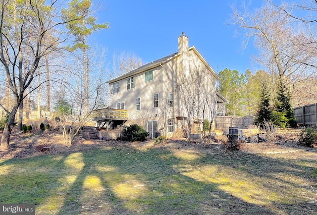 back of property with a chimney and fence