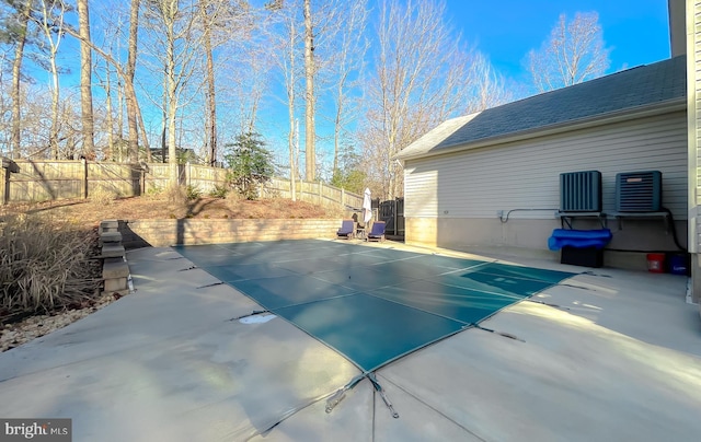 view of pool with central air condition unit, a fenced backyard, and a patio area