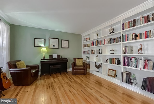 sitting room with built in features and wood finished floors