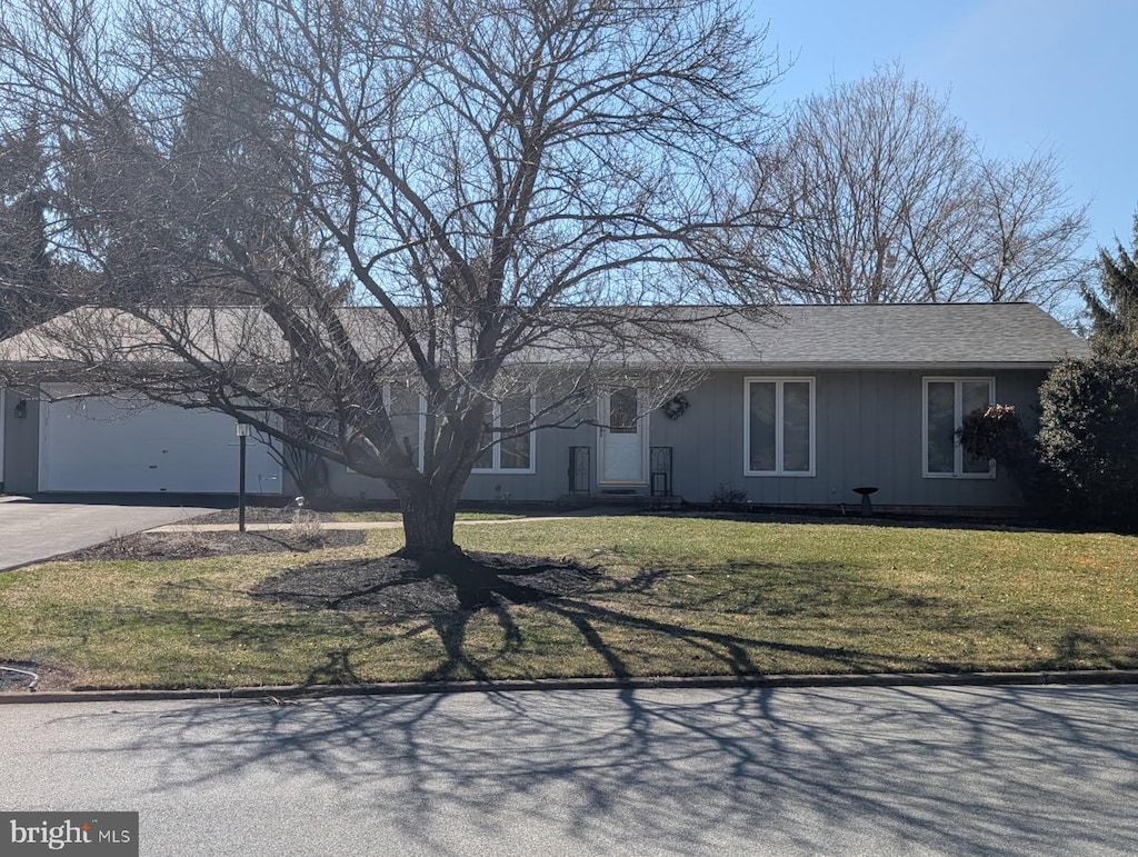 single story home with a garage, driveway, and a front lawn