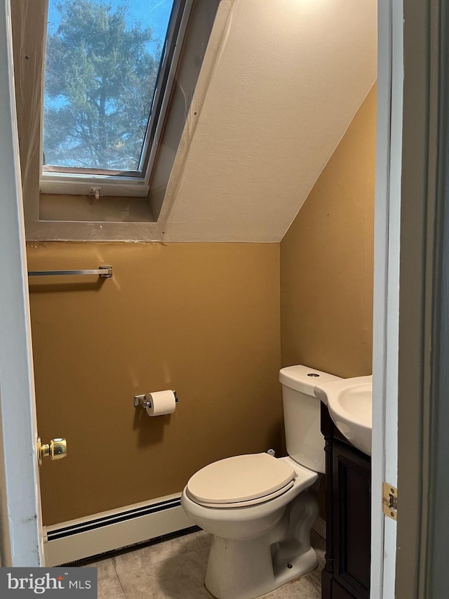 bathroom with lofted ceiling, a baseboard radiator, tile patterned flooring, toilet, and vanity