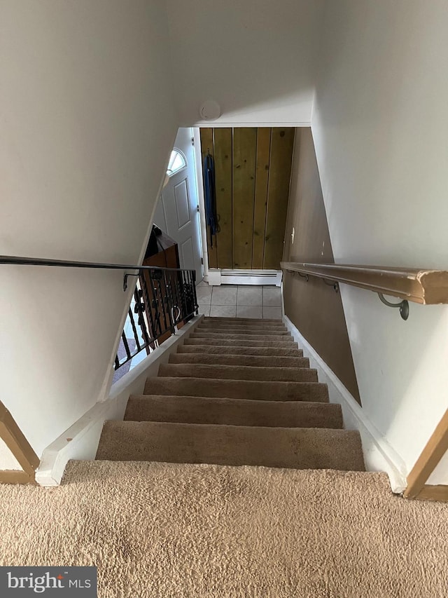 staircase featuring vaulted ceiling and baseboard heating