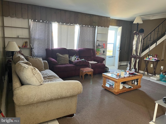 living room with a baseboard radiator and stairs