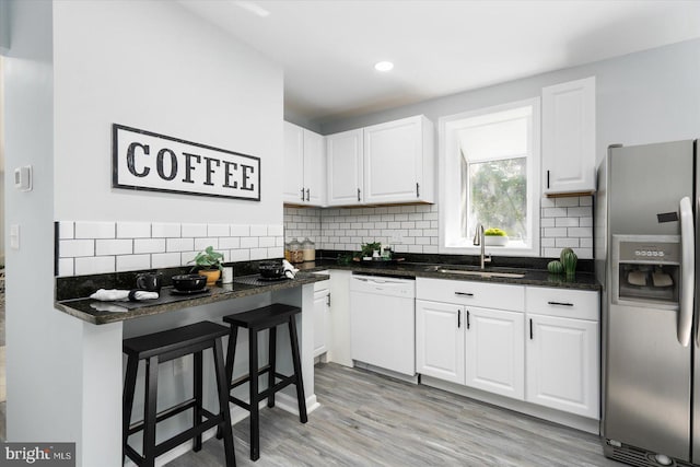 kitchen with a sink, dishwasher, white cabinetry, and stainless steel fridge with ice dispenser