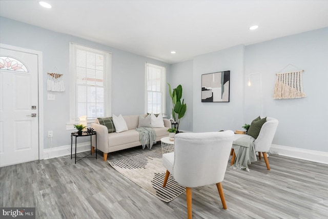 living area with recessed lighting, light wood-type flooring, and baseboards