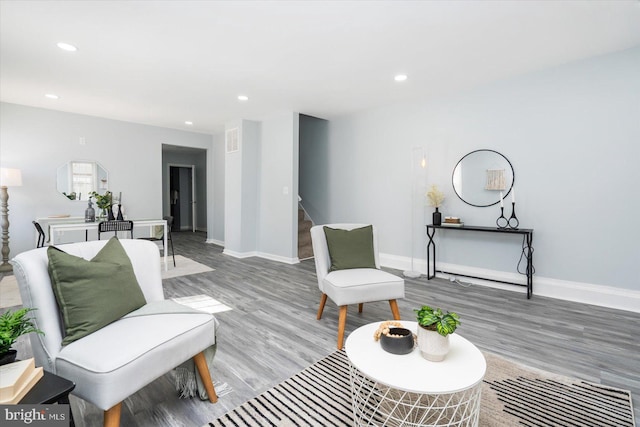 sitting room with light wood-type flooring, visible vents, recessed lighting, baseboards, and stairs