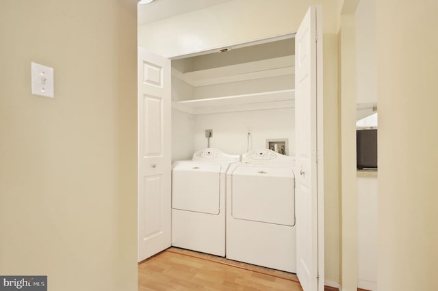 laundry room with light wood-style flooring, independent washer and dryer, and laundry area