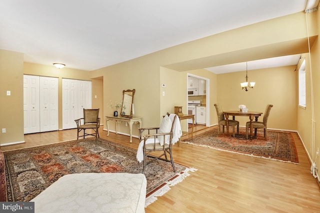 living area with a chandelier, wood finished floors, and baseboards