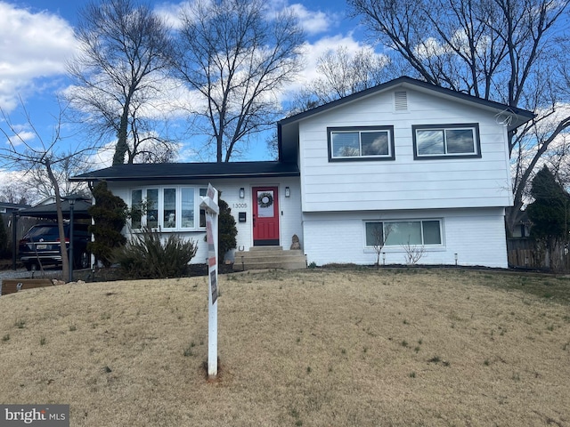 tri-level home with brick siding, a front yard, and entry steps