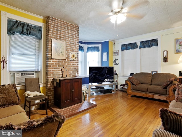 living room featuring ornamental molding, cooling unit, ceiling fan, and light wood finished floors