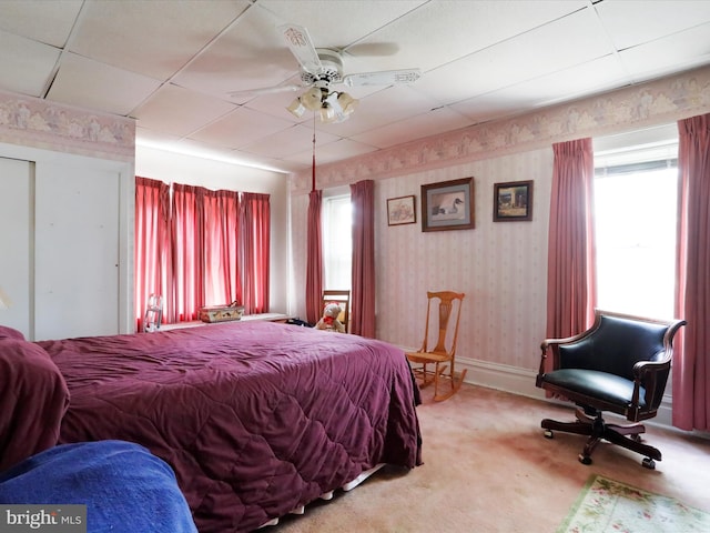 carpeted bedroom featuring baseboards, ceiling fan, multiple windows, and wallpapered walls