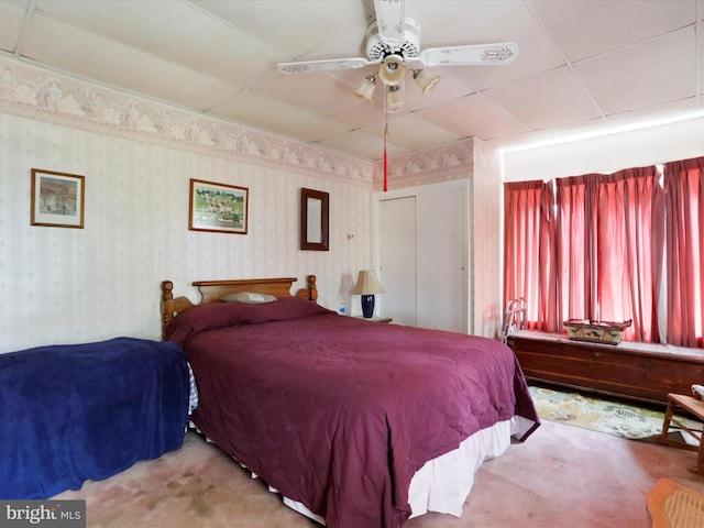 carpeted bedroom featuring wallpapered walls and a ceiling fan