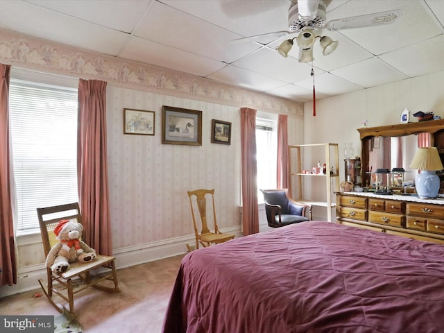 bedroom featuring multiple windows, light carpet, baseboards, and wallpapered walls