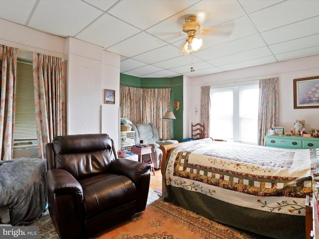 bedroom featuring a ceiling fan, a paneled ceiling, and cooling unit