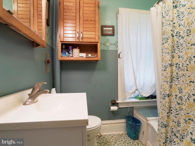 full bath featuring baseboards, vanity, and toilet