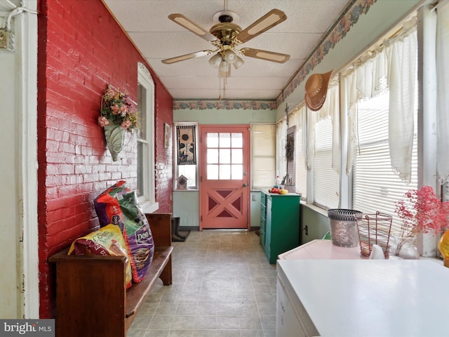 sunroom / solarium with ceiling fan and a drop ceiling