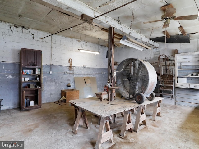 interior space featuring a ceiling fan and unfinished concrete floors