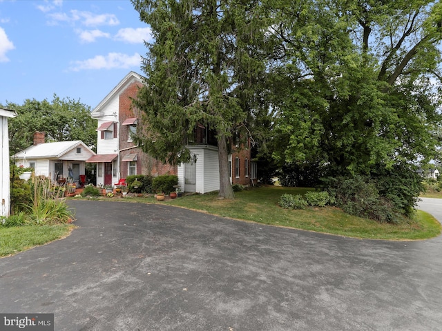 view of property hidden behind natural elements featuring a front lawn