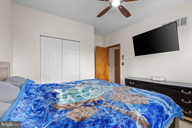 bedroom featuring a ceiling fan, a closet, visible vents, and a textured ceiling