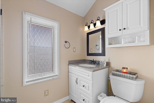 bathroom featuring toilet, baseboards, and vanity