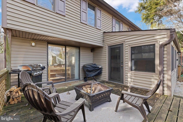 wooden terrace featuring an outdoor fire pit and area for grilling