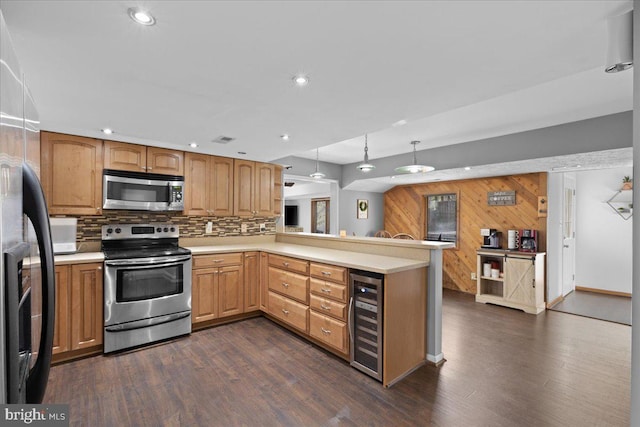 kitchen with wine cooler, dark wood-type flooring, light countertops, appliances with stainless steel finishes, and tasteful backsplash