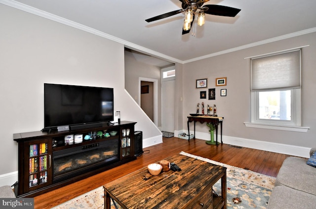 living room featuring ornamental molding, wood finished floors, and baseboards