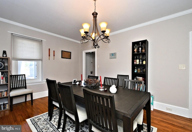 dining room with a notable chandelier, baseboards, wood finished floors, and crown molding