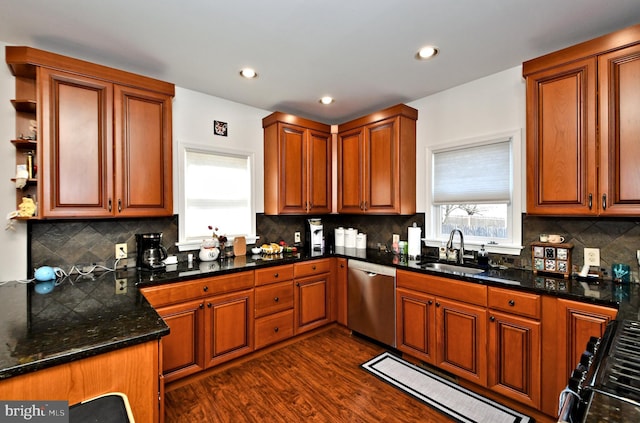 kitchen featuring brown cabinets, dark wood finished floors, black gas range oven, a sink, and dishwasher