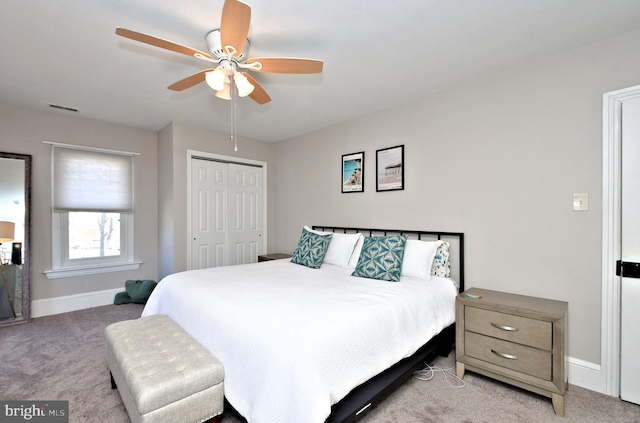 bedroom with a closet, visible vents, light carpet, ceiling fan, and baseboards