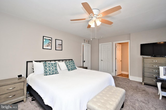 carpeted bedroom with ceiling fan and baseboards