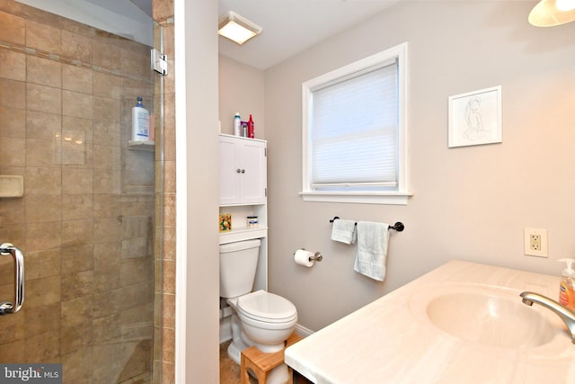 full bath featuring toilet, a stall shower, baseboards, and a sink