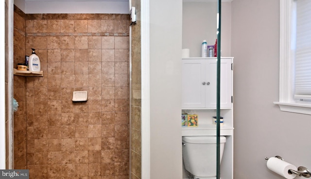 full bath featuring a tile shower and toilet