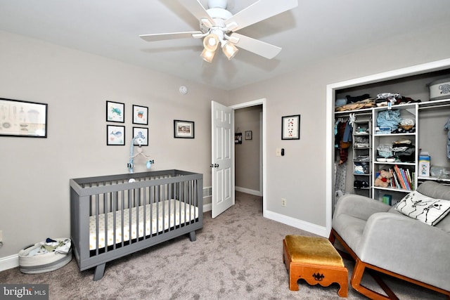 bedroom with baseboards, a ceiling fan, carpet flooring, a nursery area, and a closet