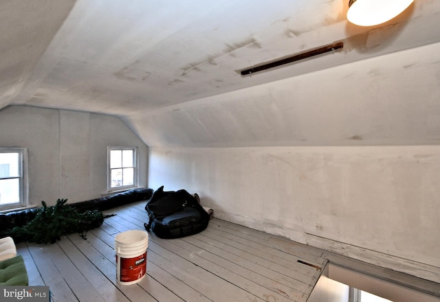 additional living space with wood-type flooring and vaulted ceiling