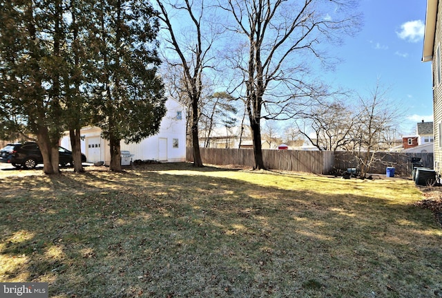 view of yard with central AC and fence