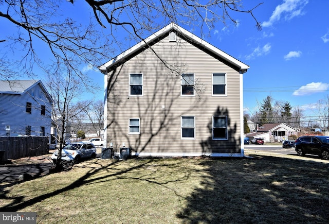 back of house with a yard, fence, and central air condition unit