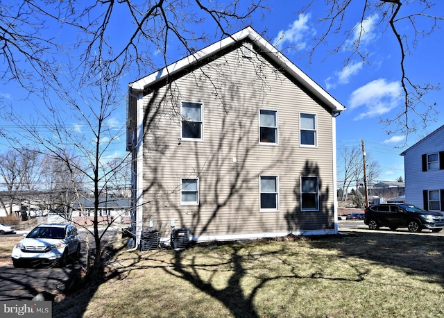 view of home's exterior with a yard and central AC