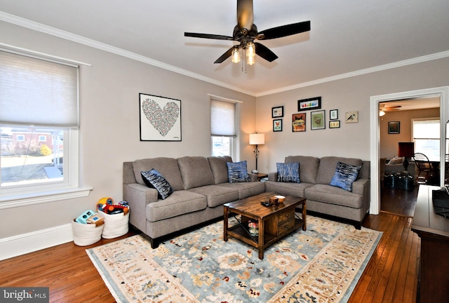 living room with dark wood-style flooring, crown molding, and baseboards