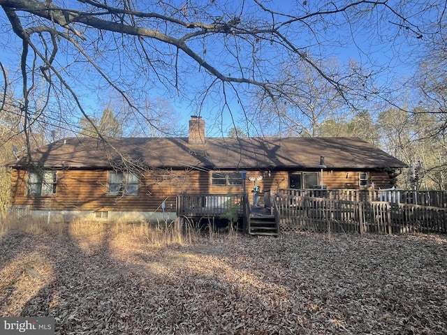 back of house featuring a deck and a chimney