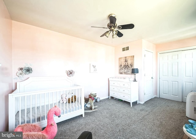 carpeted bedroom with visible vents, a ceiling fan, a closet, a nursery area, and baseboards