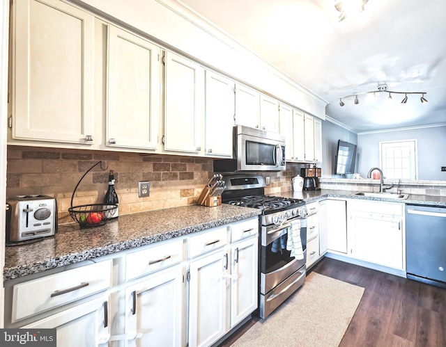 kitchen with crown molding, decorative backsplash, appliances with stainless steel finishes, dark wood-style floors, and a sink