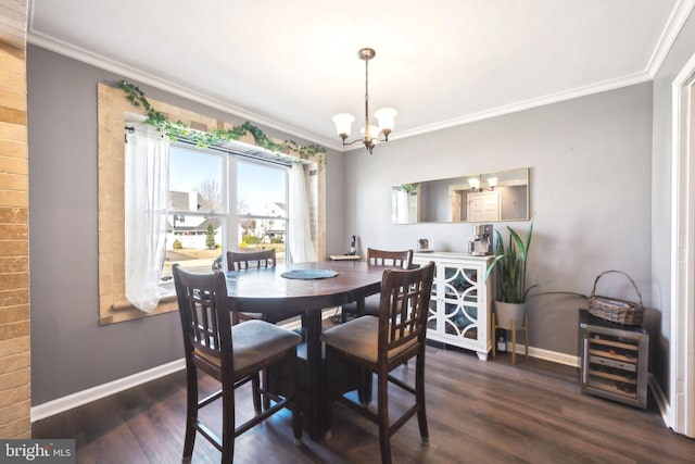 dining space featuring dark wood finished floors, crown molding, baseboards, and a chandelier