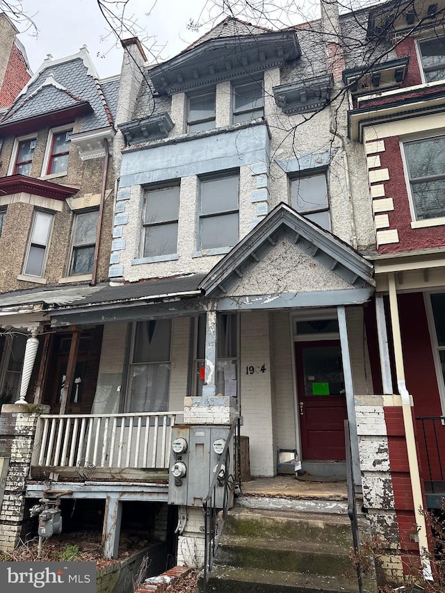 view of front of house with a porch and brick siding