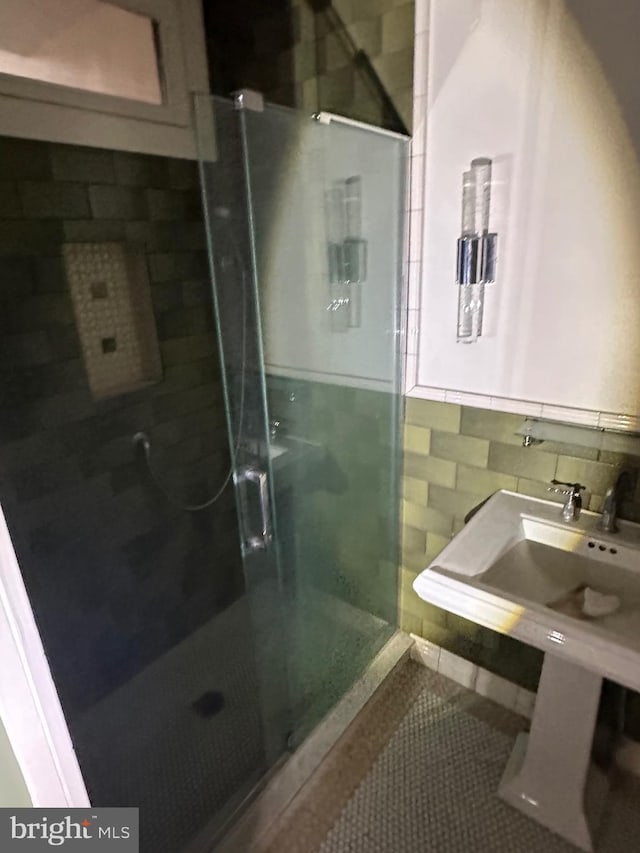 bathroom featuring tile patterned flooring, a shower stall, and tile walls