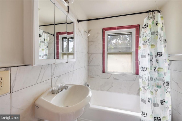 full bathroom featuring shower / bath combination with curtain, a wealth of natural light, tile walls, and a sink