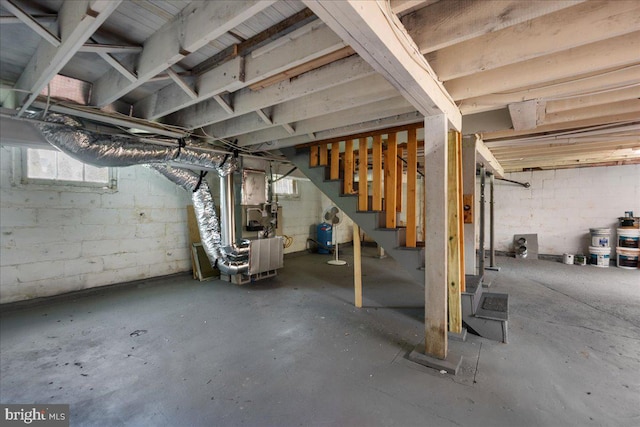 basement featuring heating unit and stairway