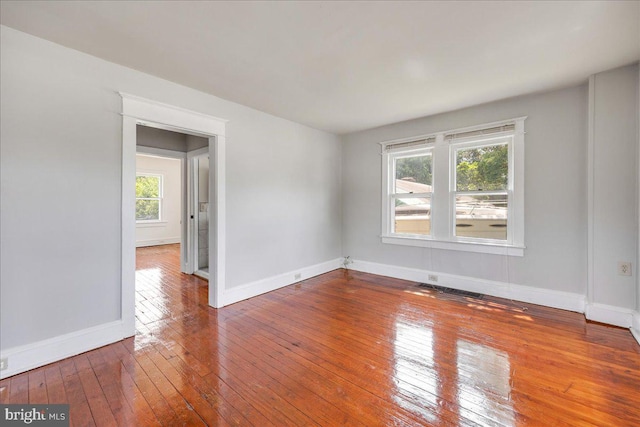 empty room with baseboards and hardwood / wood-style floors